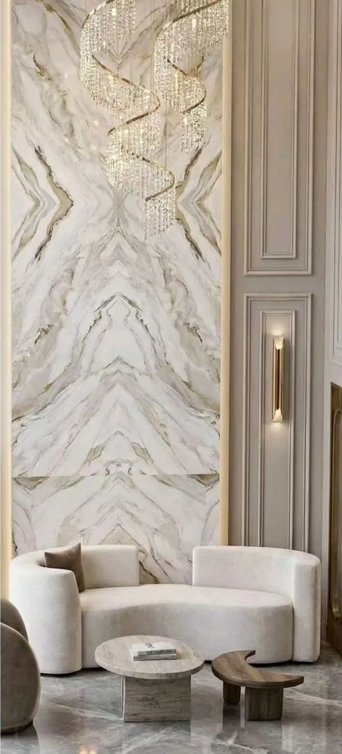Double-height lounge with spiral crystal chandelier and marble feature wall